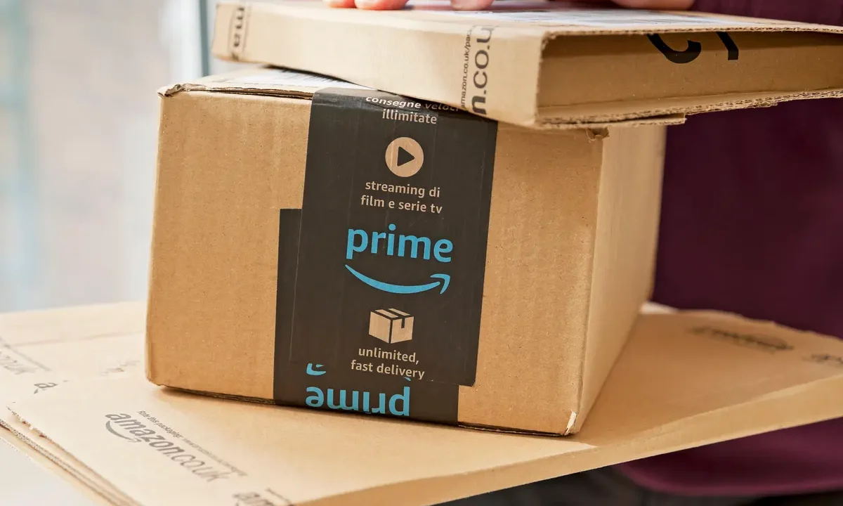 An image of someone holding a pile of Amazon Prime boxes.