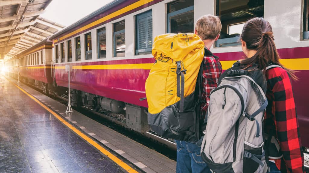 students with backpacks waiting for the train